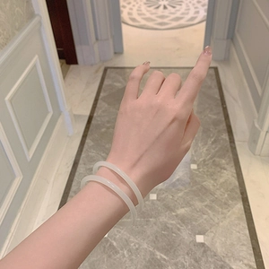 Close-up of dual white translucent resin bangles on wrist with a minimalist style