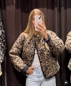 Detail of leopard print quilted short jacket with black trim and classic animal pattern