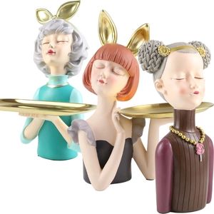 Detailed view of resin girl figurines in various colors holding gold display trays
