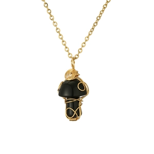 Macro shot of black agate mushroom pendant wrapped in golden wire on a gold chain