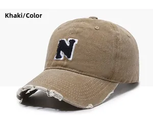 Close-up of khaki vintage baseball cap with N logo embroidery and distressed brim details