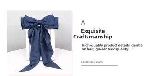 Detail of elegant dark blue satin bow hair clip with long ribbons and smooth texture