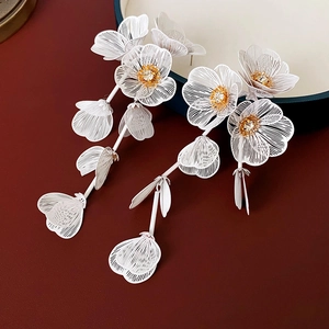 Détail de la boucle d'oreille à pampilles avec pétales blancs et cristal central