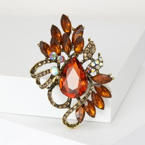 Close-up of vintage gold brooch with amber crystal teardrop and AB rhinestones