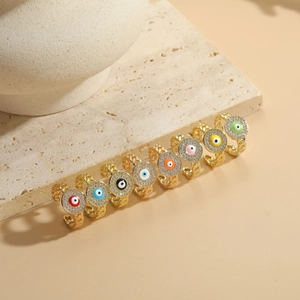 Close-up of 14K gold plated evil eye earrings set with colorful zircon stones on stone