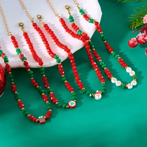 Detail of Christmas beaded necklaces with Santa and HOHO pendants on festive green background