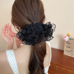 Détail d'un chouchou élégant en dentelle noire avec froufrous porté par un mannequin