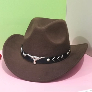 Detail of brown felt cowboy hat featuring silver bull head metal and studded leather band