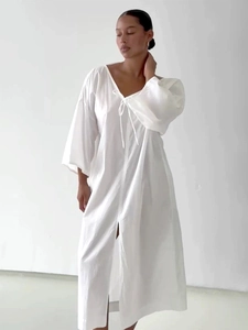Detail of V-neck drawstring and lantern sleeves on a white cotton vacation dress