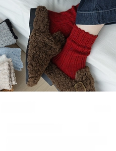 Detailed texture of thick flecked wool socks in red, blue, grey and beige colors