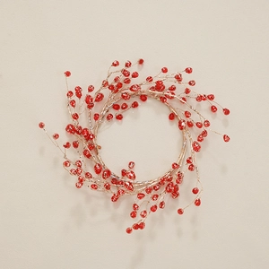 Elegant Christmas wreath with red acrylic berries and gold wire on a beige background
