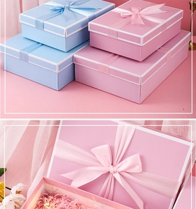 Pink gift box with ribbon bow, shredded paper filler and decorative LED light string detail
