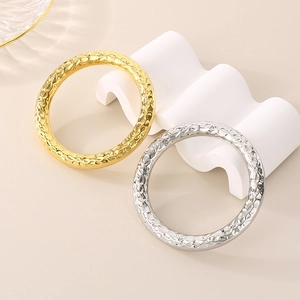 Detail of hammer textured gold and silver stainless steel bangles on display