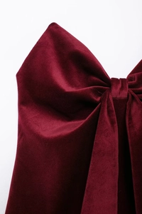Détail du grand nœud en velours rouge sur haut bustier montrant la texture du tissu