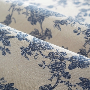 Close-up macro detail of premium cotton linen tablecloth with elegant blue floral pattern