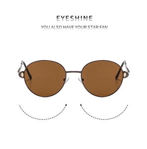 Detail of round metal sunglasses with vintage rhinestones and gold accents on temples