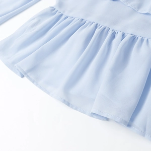 Dettaglio dell'orlo con volant e della trama del tessuto in chiffon azzurro plissettato