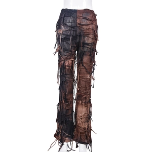 Dettaglio dei pantaloni stile wasteland con nastri a frange e design patchwork unico