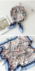 Detail of light blue bordered silk scarf with geometric patterns on ivory background