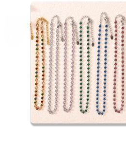 Macro view of colorful zircon tennis necklaces with S.Steel engraved tags in various finishes