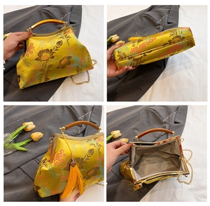 Detail view of yellow silk embroidery bag with bird pattern, wooden handle and golden chain