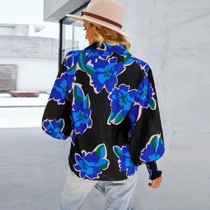 Vista posteriore della camicia nera a maniche lunghe con motivi floreali blu e verdi