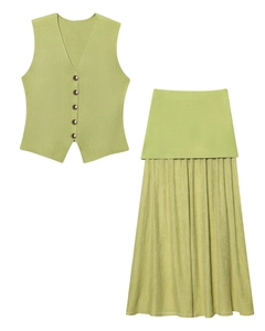 Détail du gilet en tricot vert sauge avec boutons en métal et jupe longue plissée