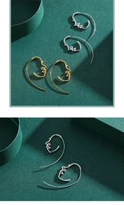 Detail view of abstract minimalist face line earrings in polished gold and silver finishes