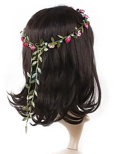 Detail of floral bridal headband with pink roses, blue berries, and long green vine leaves