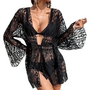 Detail of black crochet lace beach cover-up featuring geometric hollow patterns and flared sleeves