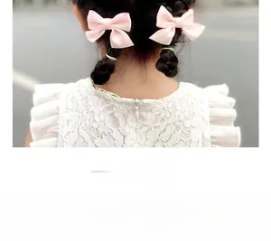 Detailed view of pink ribbon bow hair clips with a model wearing them in a hairstyle