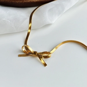 Elegant 18K gold-plated bow snake chain necklace for women featuring a minimalist choker style