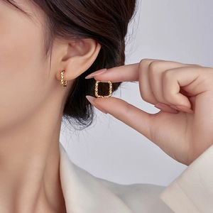 Detailed view of irregular 18K gold stainless steel hoop earrings worn by a model
