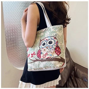 Detailed texture of ethnic canvas tote bag with colorful cartoon owl and LOVE YOU embroidery