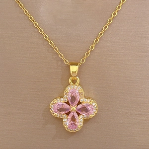 Macro shot of gold floral necklace with pink teardrop crystal and sparkling zircon accents