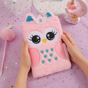Detailed view of pink plush owl notebook with silver glitter crown and embroidery held by hands