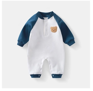 Detail eines Baby-Stramplers mit süßem braunem 3D-Bären-Stick und marineblauen Ärmeln