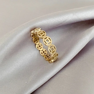 Close-up detail of golden ring featuring traditional Chinese copper coin patterns