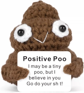 Macro shot of handcrafted crochet positive poo doll with inspirational card on white base