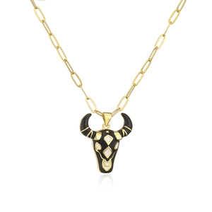 Detailed view of 18K gold plated bull head pendant with black and white enamel finish
