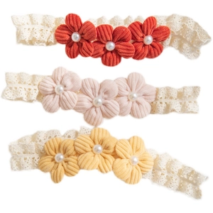 Three corduroy flower baby headbands with lace straps in red, pink, and yellow colors