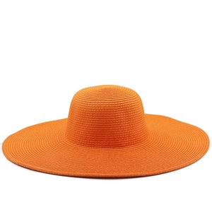 Detail of orange woven straw sun hat showing the wide brim and fine braided texture