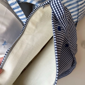 Détail du sac en coton à carreaux bleus et blancs avec broderie florale et zip métallique