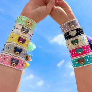 Close-up detailed view of colorful woven bear bracelets with crystal and tassel accents.