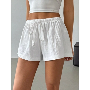 Detail of white cotton linen shorts featuring an elastic waistband and adjustable drawstrings