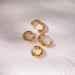 Detail of four golden 4mm thick stainless steel hoop earrings with hinged closures