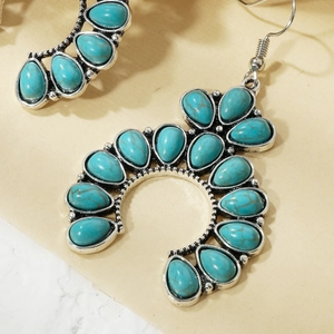 Macro view of Bohemian silver earrings with teardrop turquoise stones and ethnic patterns