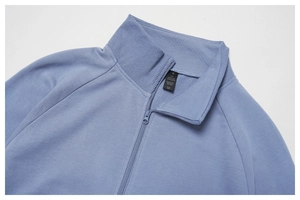 Detail eines blauen Sweatshirt-Kragens mit Waschetikett aus 83 % Baumwolle und 17 % Polyester