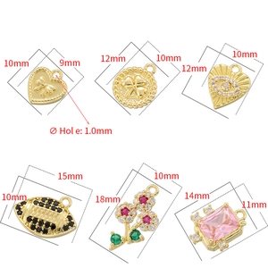 Collection of gold-plated metal charms with heart, clover, and flower motifs in varied sizes
