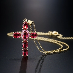 Elegant 18K gold plated necklace with a red zircon cross pendant on a reflective background